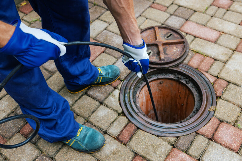 sewer cleaning service – worker clean a clogged drainage with hydro jetting